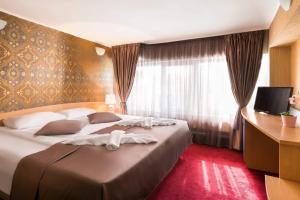 um quarto de hotel com uma cama grande e uma janela em Hotel Central Point em Sófia