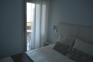 カディスにあるApartamento Playa Victoria - Cádizのベッドルーム1室(ベッド1台付)、窓、バルコニーが備わります。