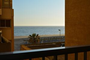 a view of the beach from a balcony at Apartamento Playa Victoria - Cádiz in Cádiz