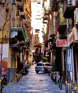 una calle de la ciudad con un letrero de bar en un edificio en Parthenope's Nest, en Nápoles