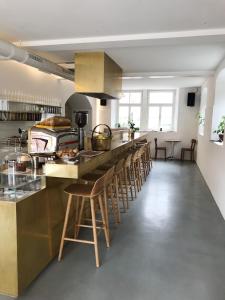 a kitchen with a counter with a row of stools at BAR10ZIMMER in Dornbirn