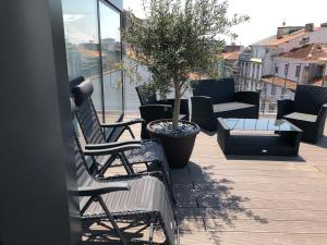 a balcony with two chairs and a potted tree at URBAN VIEWS Terrace - Duplex Apartment "Maria Pia" in Porto