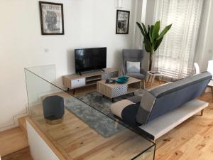 a living room with a couch and a tv at URBAN VIEWS Terrace - Duplex Apartment "Maria Pia" in Porto