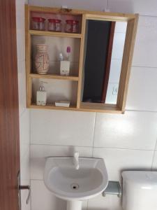 y baño con lavabo y espejo. en Casa de Temporada en Cabo Frío