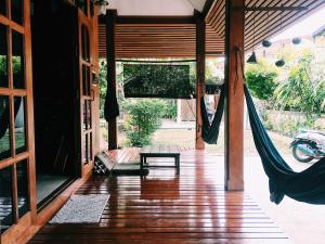 a porch with a hammock and a swing at Baan Mai Sak in Pai
