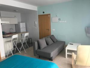 ein Wohnzimmer mit einem Sofa und einer Küche in der Unterkunft Calle Ollerias in Málaga
