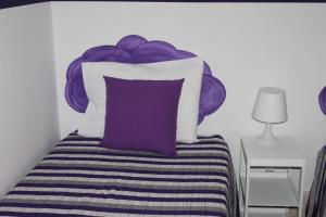 a bed with a purple and white pillow on it at Lisboa Sunshine Homes in Lisbon