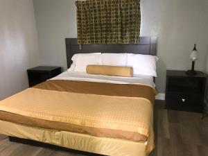 1 dormitorio con 1 cama con cabecero marrón en Belmont Inn & Suites Virginia Beach, en Virginia Beach