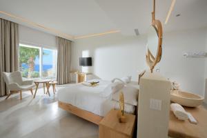 biała sypialnia z łóżkiem, stołem i krzesłem w obiekcie Anax Resort and Spa w mieście Agios Ioannis +37 zdjęć