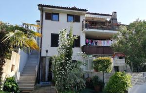 ein weißes Haus mit Balkon und Wäscheleine in der Unterkunft MILLENCA Apartment in Izola