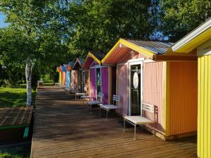 a row of colorful homes on a wooden deck at Jaaguranna Lillelaager in Tõstamaa