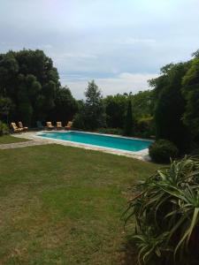 uma piscina num quintal ao lado de um campo em Casa Ramoniña em Ribeira