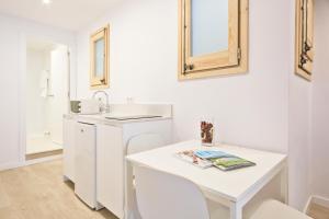 a white kitchen with a sink and a table at BcnStop Sagrada Familia in Barcelona +26 photos
