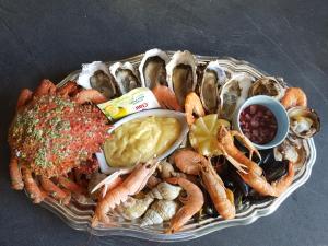 a plate of shrimp and other seafood on a table at Le Relais De La Chaussee in Neuilly-la-Forêt
