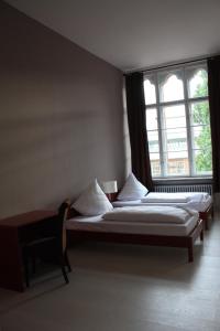 two beds in a room with two windows at PLUS Berlin Hostel und Hotel in Berlin