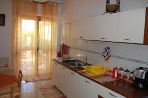 トッレ・ア・マーレにあるAppartamento in villaの白いキャビネットとシンク付きのキッチン