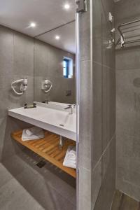 a bathroom with a sink and a shower at Silver Beach Hotel & Apartments in Gerani