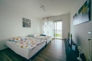 a bedroom with two beds and a television in it at Apartmani Josip in Podstrana