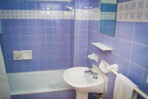 a bathroom with a sink, toilet, and bathtub at Marcopolo Inn Hostel Bariloche in San Carlos de Bariloche