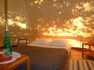 a bedroom with a bed and a wall with clouds at Camping Etang Du Camp in Sénergues