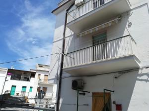 ein weißes Gebäude mit einem Balkon an der Seite in der Unterkunft Casa vacanze da Michela in Peschici