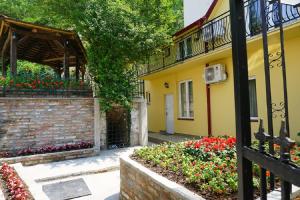 a yellow building with flowers in a garden at Male stepenice in Belgrade