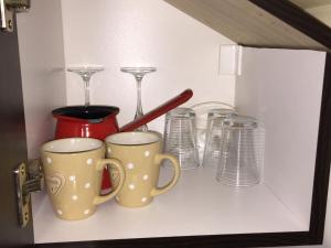 - une étagère avec deux tasses à café et des verres dans l'établissement Simic, à Aranđelovac