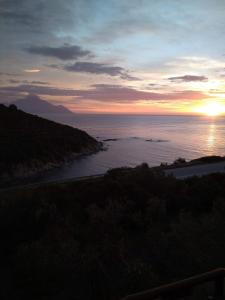 een zonsondergang boven een lichaam van water met de oceaan bij Villa Haris in Sarti