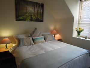 een slaapkamer met een groot wit bed met 2 lampen bij Seascape Largo in Lundin Links