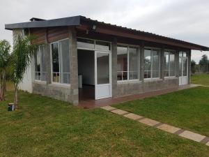 un edificio con puertas de cristal y un campo de césped en Cabañas Ceferino en Federación