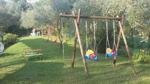 a swing set in a park with a bench at La Casa Rosa in Borghetto di Vara