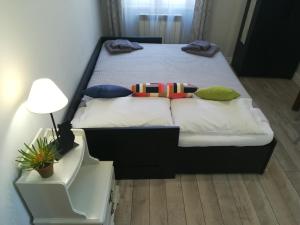 1 dormitorio con 1 cama con almohadas y lámpara en Le Volute al Pigneto, en Roma