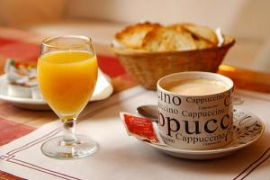 a glass of orange juice and a cup of coffee on a table at Hotel Continental Express in Barranquilla