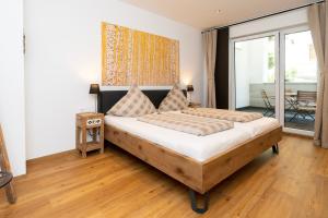 a bedroom with a large bed and a balcony at Old Town Apartments in Kaufbeuren