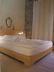 a wooden bed in a bedroom with a mirror at Gite la Tour in Pépieux