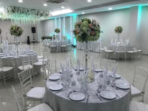 a banquet hall with white tables and chairs and flowers at Hotel Continental Express in Barranquilla
