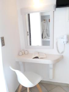a white desk with a mirror and a white chair at Nikos Apartments and Studios in Agios Prokopios