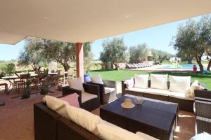un patio con sofás, mesa y sillas en Villa Kristy en Marrakech