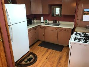 a kitchen with a white refrigerator and a sink at Gonzales Cozy Little Bear Cabin in Ruidoso