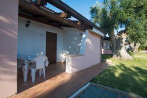 un patio con una mesa y un árbol en Cilento Dreams Village en Marina di Camerota