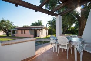 um pátio com uma mesa e cadeiras num alpendre em Cilento Dreams Village em Marina di Camerota