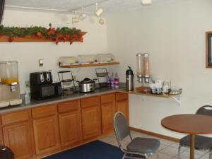 une cuisine avec un comptoir et une table avec des chaises dans l'établissement USA Inns of America, à Doniphan