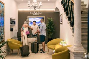 een man en een vrouw in een lobby met bagage bij Scalini Palace in Dubrovnik