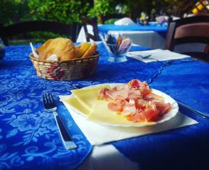 un tavolo con un piatto di cibo e un cesto di pane di Agriturismo Sa Pramma a Santa Maria la Palma