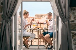 
two people sitting at a table eating food at Scalini Palace in Dubrovnik
