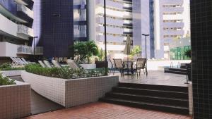 a patio with chairs and tables in a city at LIV INN Apartamento na Beira-Mar Fortaleza in Fortaleza