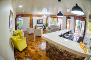 a kitchen and living room with yellow chairs and a counter at Oasis Hotel in Palmitos