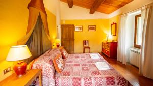 um quarto com uma cama e uma mesa com um candeeiro em Casa Rosa em Santa Maria Lignano