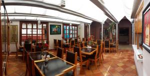 サン・クリストバル・デ・ラス・カサスにあるアクスカン アルテ ホテルのテーブルと椅子が備わるレストラン