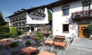 an outdoor patio with tables and chairs in front of a building at Hotel am Wald in Bad Tölz